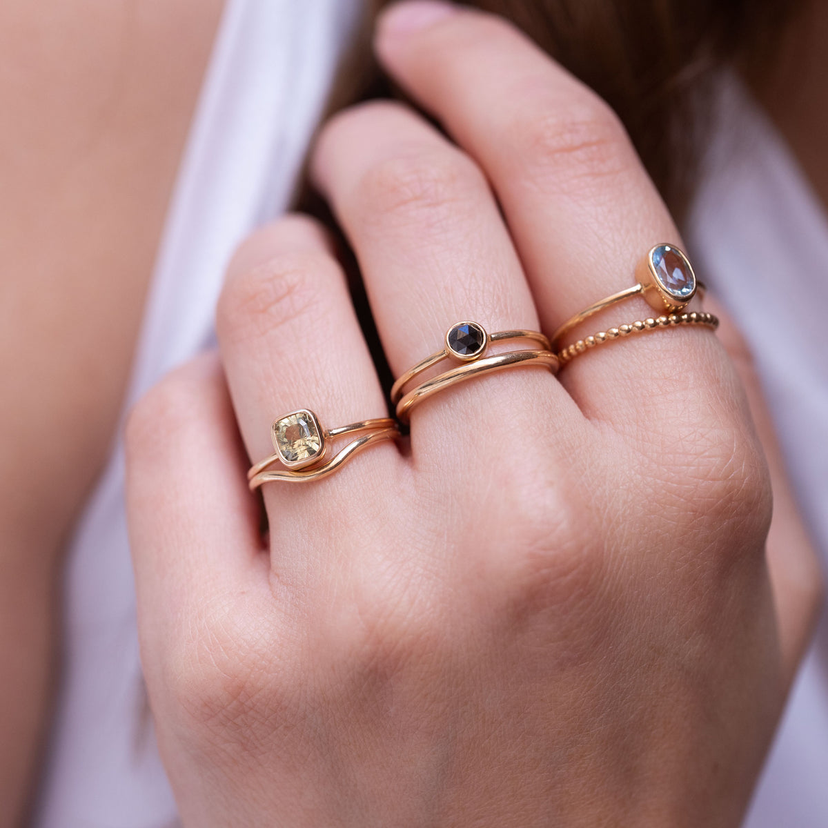 hand wearing gold rings