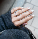 hand with silver stacking rings