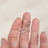 hand with handmade gold rings with diamonds and lilac sapphires