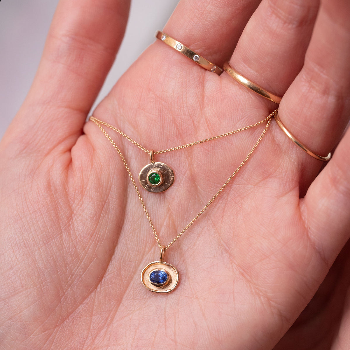 hand holding gold necklaces
