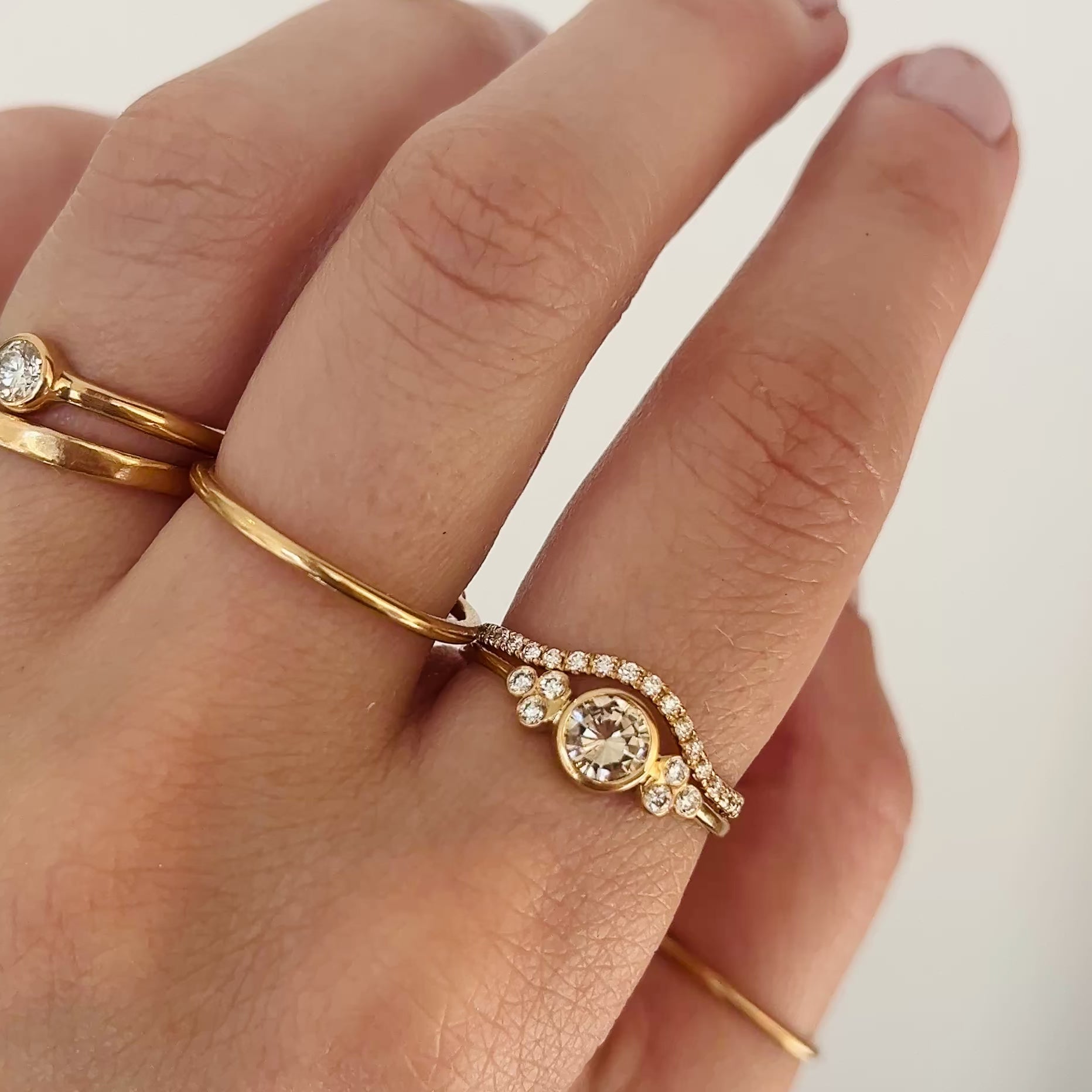 hand wearing gold rings with diamonds