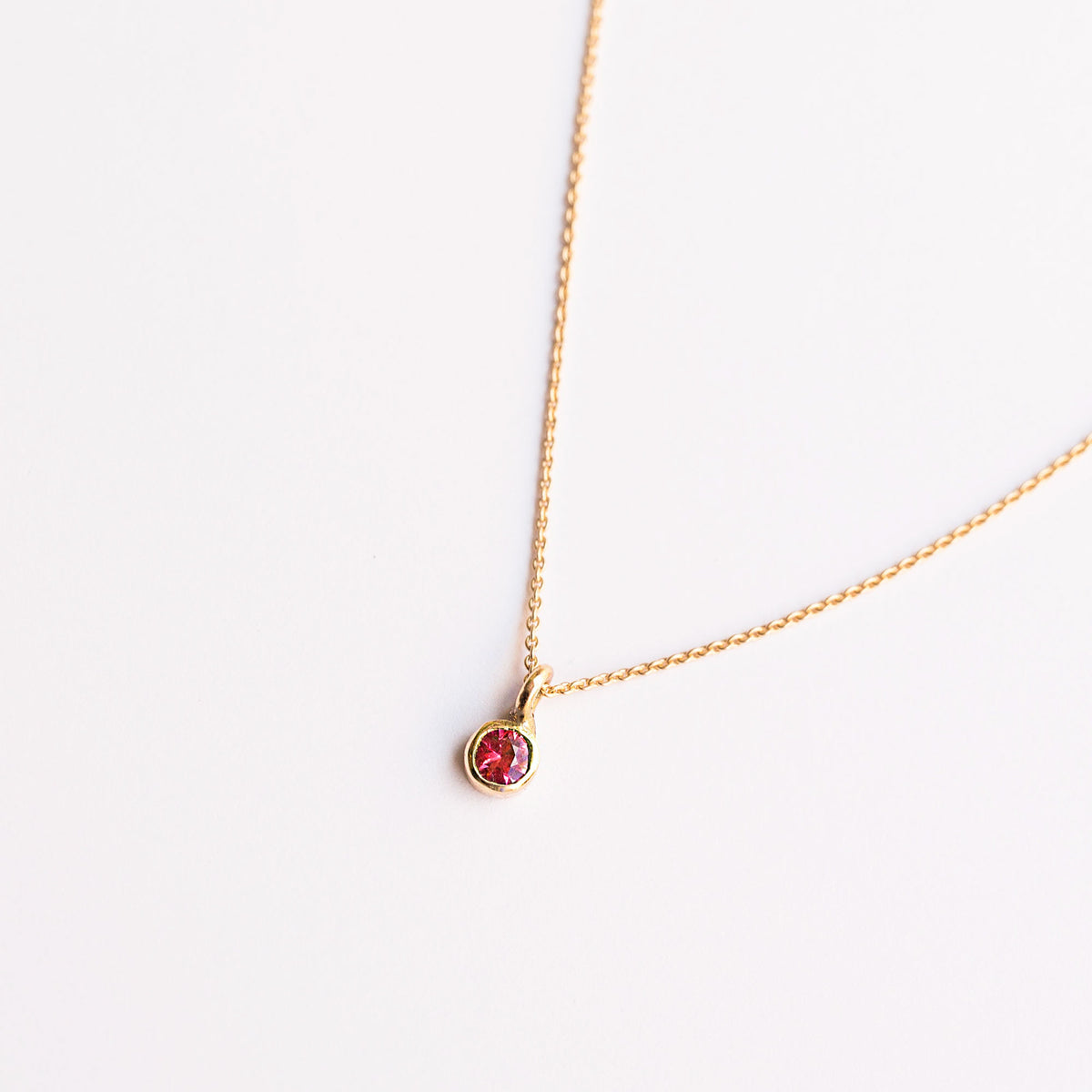 18k gold necklace with a round ruby